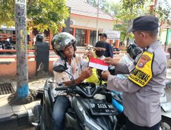 Jelang Hari Kemerdekaan, Bhabinkamtibmas Polsek KPN Bagikan Bendera Merah Putih ke Warga
